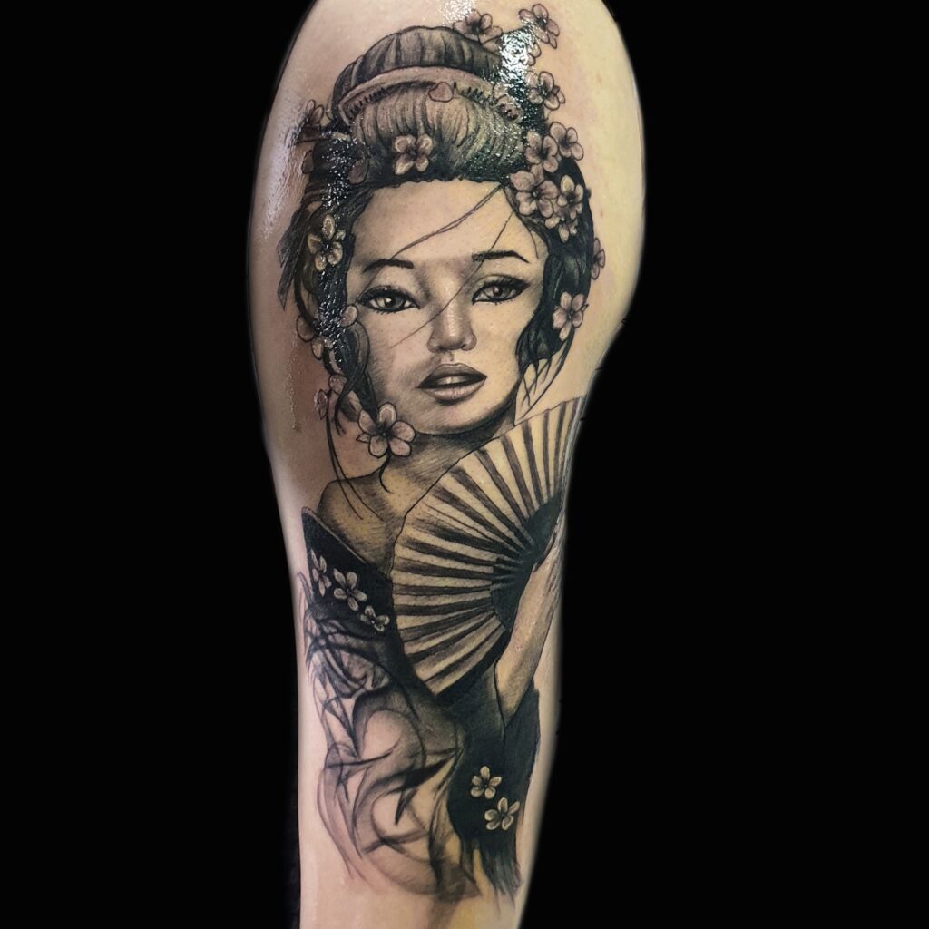Black and grey geisha portrait tattoo with cherry blossoms by Uppercuts Tattoo Shop, Maple Ridge BC